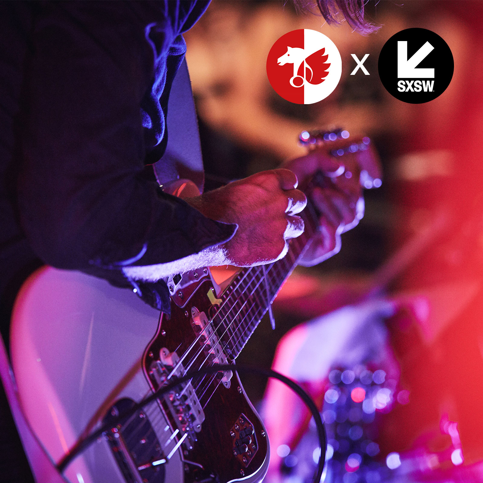 Gitarrist spielt E-Gitarre in pinkem Licht