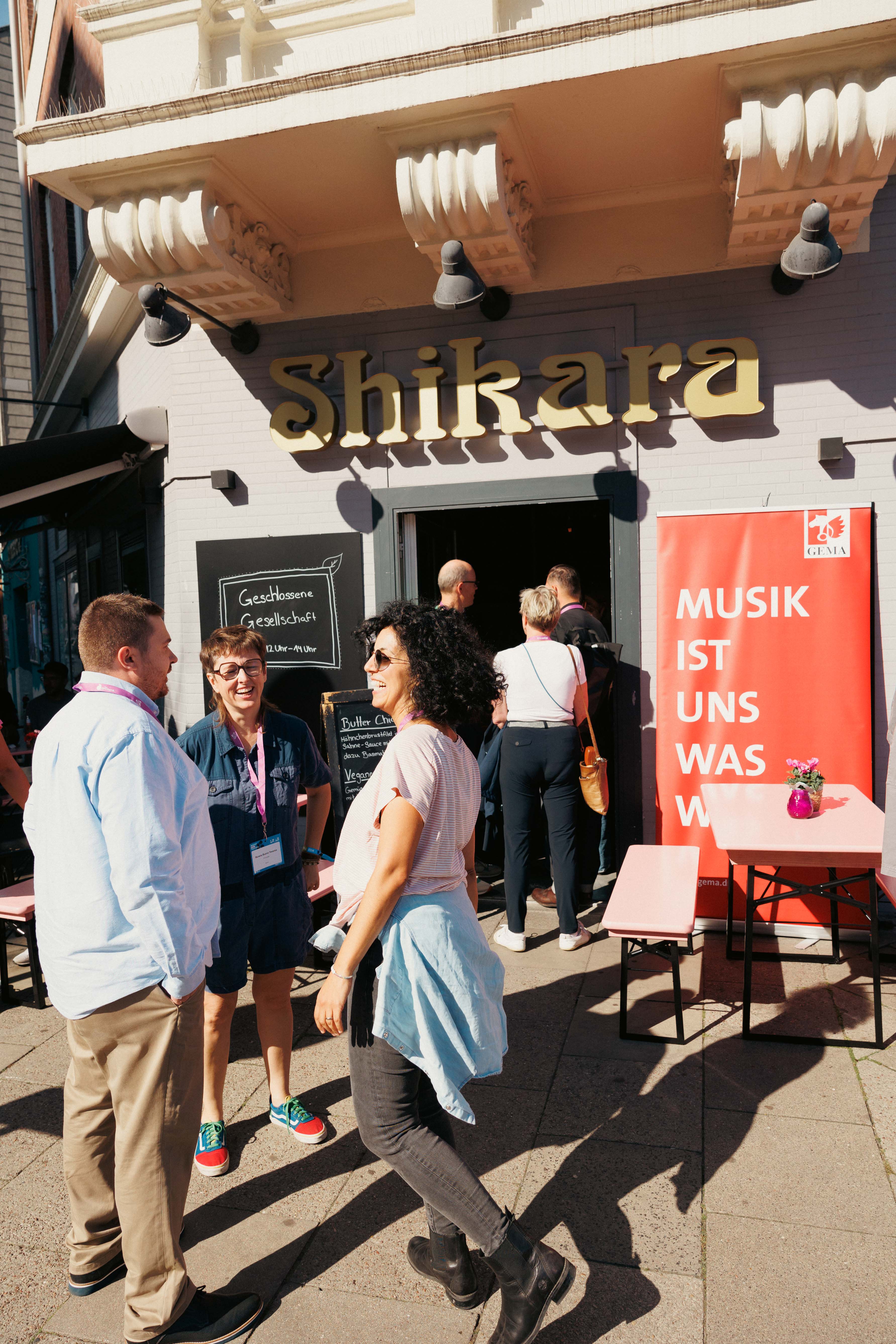 Personen unterhalten sich vor einem Café mit 