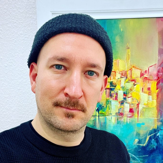 Eine Person mit Mütze vor einem bunten, abstrakten Gemälde an einer weißen Wand.