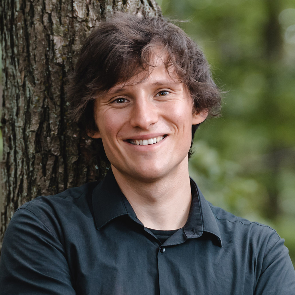 Ludwig Wright Komponisten, angelehnt an einen Baum.