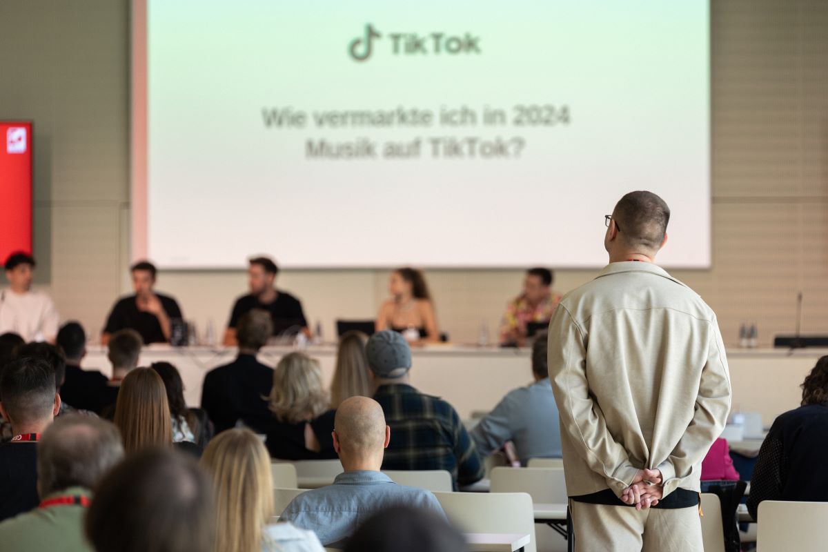 Eine Konferenz über Musikmarketing auf TikTok im Jahr 2024 mit einem Publikum und einer Podiumsdiskussion.