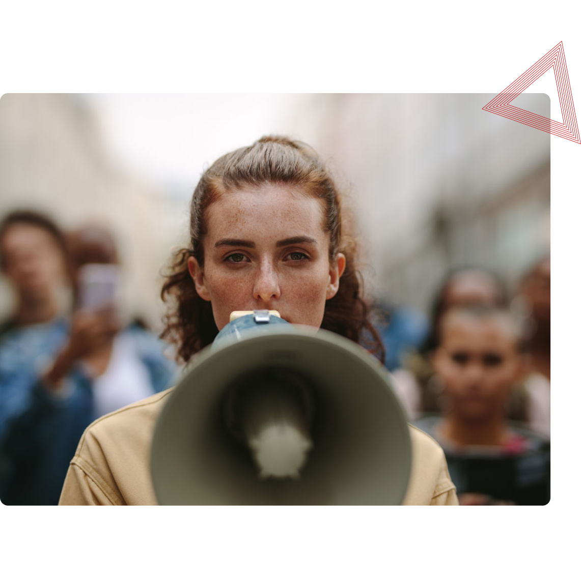 Eine Frau spricht in ein Megafon, Menschen im Hintergrund.