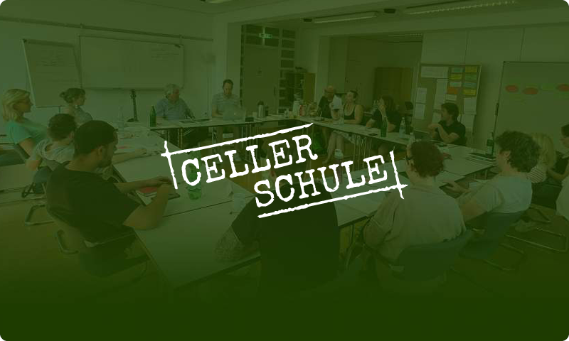 Eine Gruppe von Menschen sitzt in einem Konferenzraum an einem großen Tisch. Text: Celler Schule.