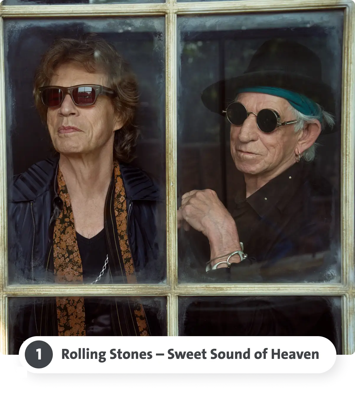 Zwei Männer mit Sonnenbrillen schauen aus einem Fenster, einer trägt einen Hut. Darunter steht 