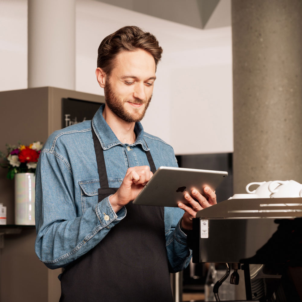 Mann mit Tablet und Schürze in einem Restaurant