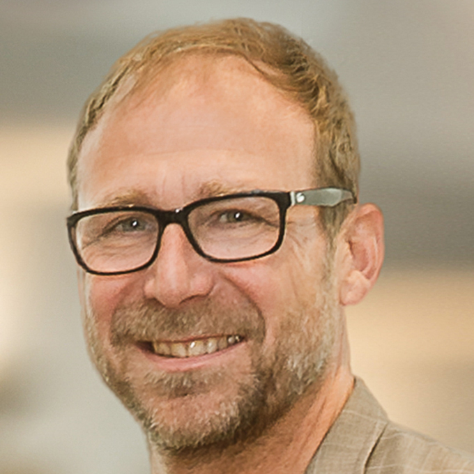 Ein Mann mit Brille lächelt in die Kamera.