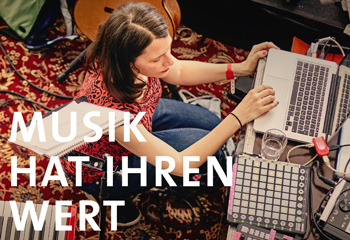 Frau am Laptop auf Teppich, umgeben von Musikinstrumenten und Audiogeräten. Text: