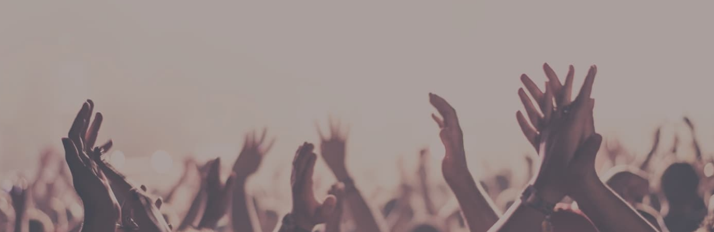 Menschen klatschen und heben die Hände in einer jubelnden Menge.