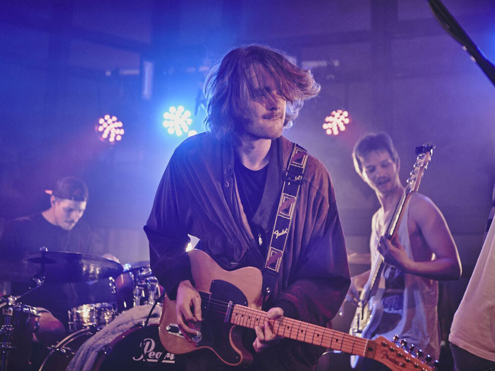 Mann mit Gitarre auf der Bühne