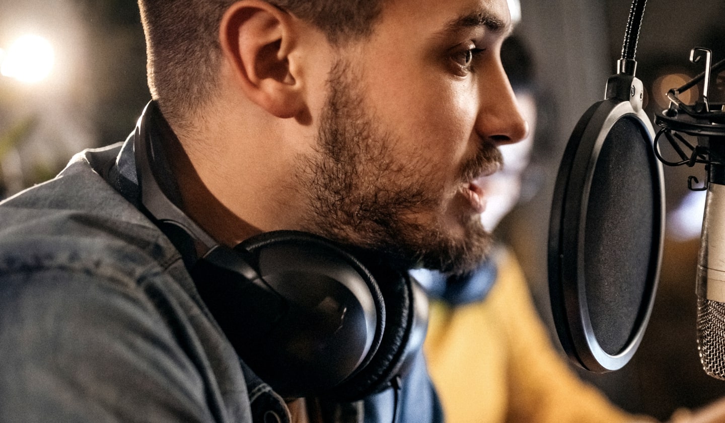Ein Mann mit Kopfhörern spricht in ein Mikrofon.