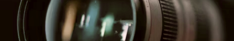 Nahaufnahme eines Kameraobjektivs mit dunklem Hintergrund.