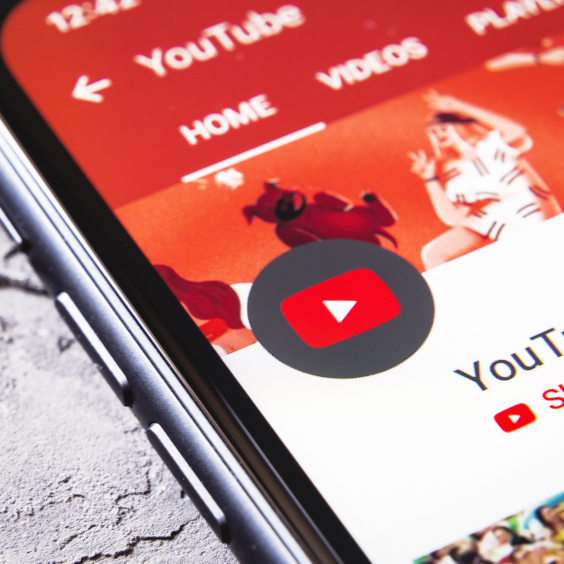 YouTube-App auf Smartphone-Bildschirm mit rotem Hintergrund und Play-Button-Symbol.